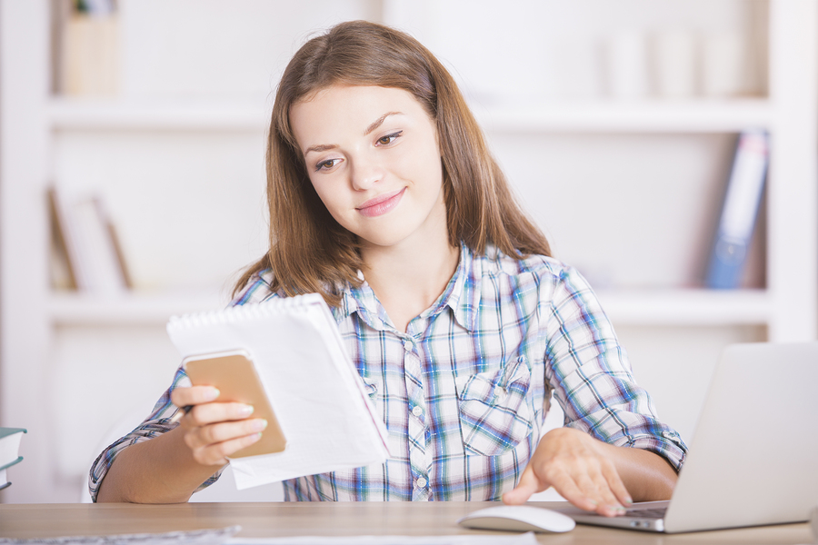 Smiling woman doing paperwork -- good financial habits