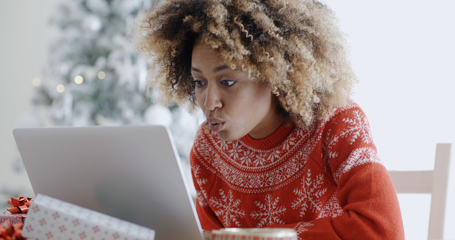 Excited woman shopping online for Christmas bargains pursing her lips in astonishment as she spots something she desires.